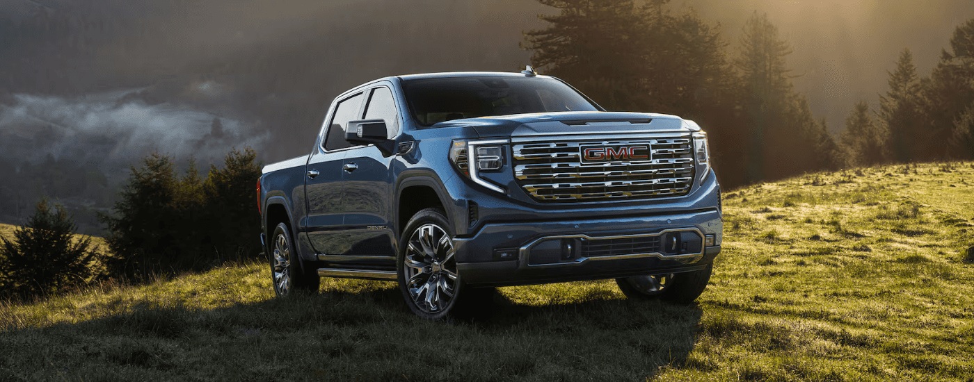 Blue 2026 GMC Sierra 1500 parked on a grassy knoll