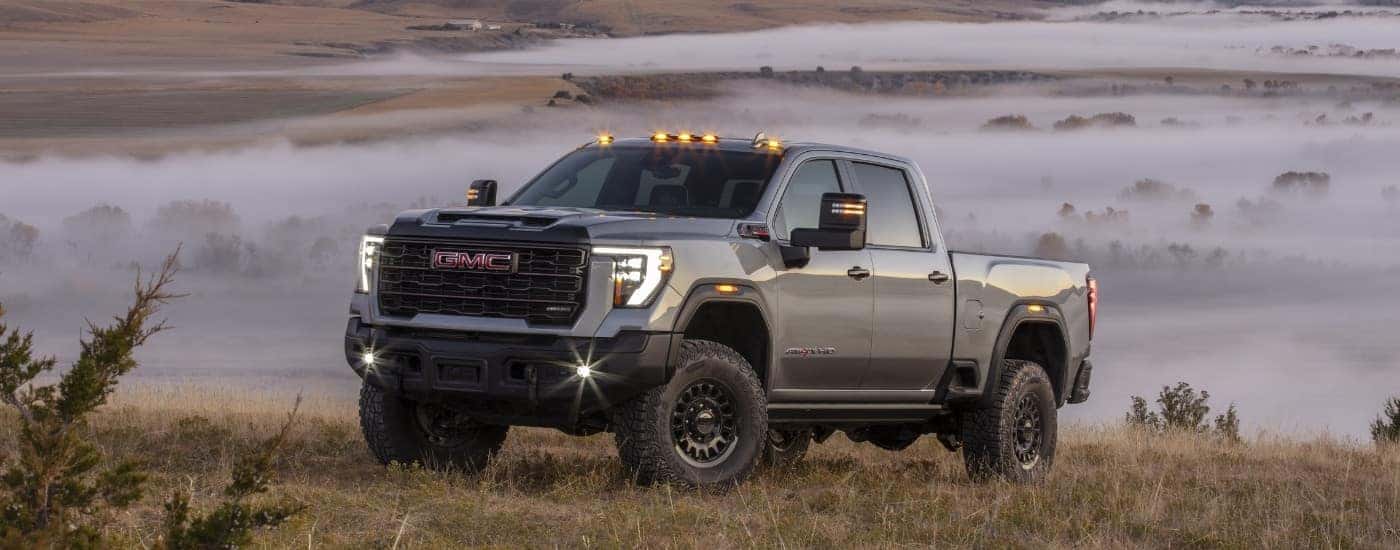 A grey 2025 GMC Sierra 2500 HD from the side after leaving a dealer with trucks for sale near Greensboro.