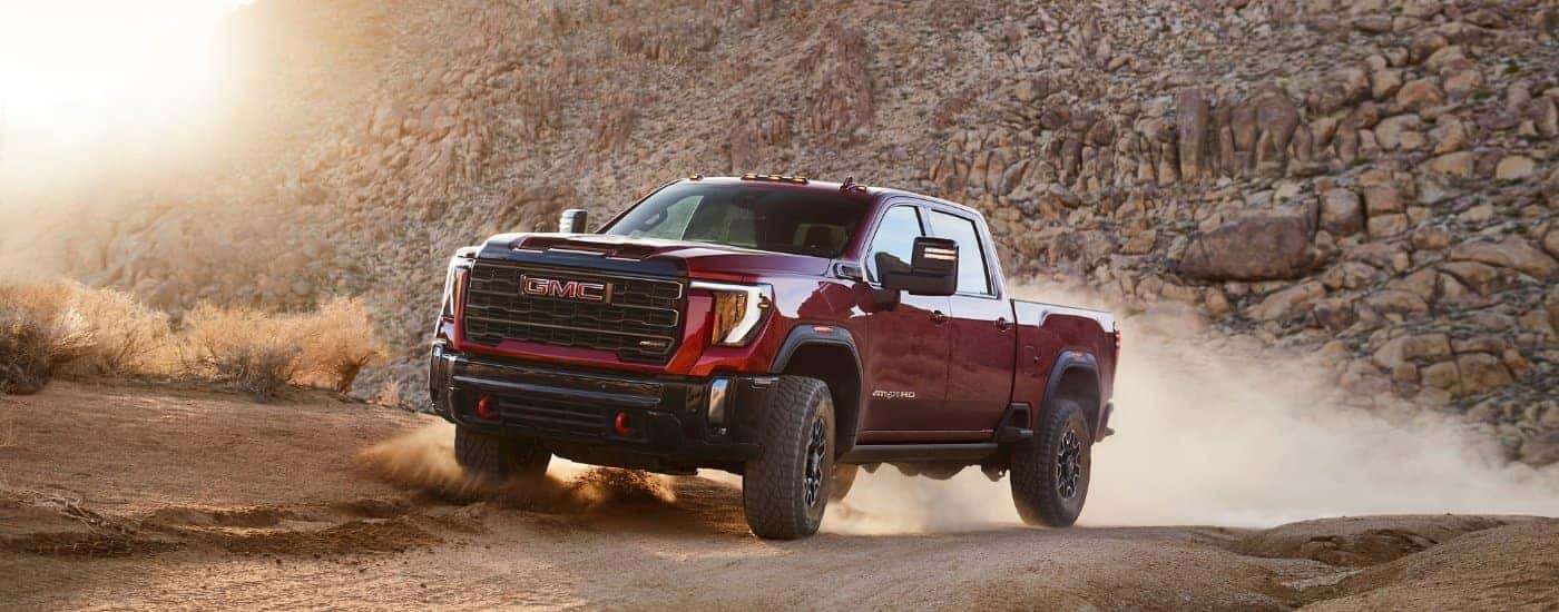 A red 2025 GMC Sierra 2500 from the side after leaving a dealer that has trucks for sale in Kernersville.