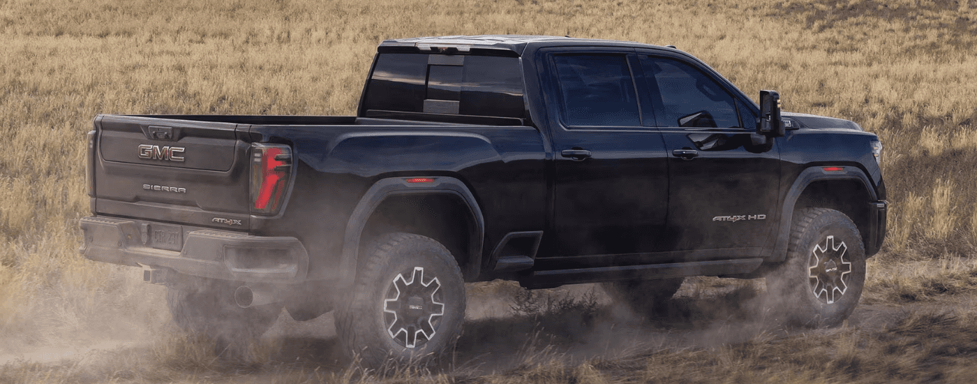 Black 2026 GMC Sierra AT4X HD driving to look at trucks for sale near Winston-Salem