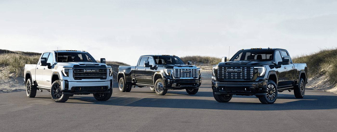 A white and a black 2026 GMC Sierra 2500 HD for sale near Thomasville parked next to a black 2026 GMC Sierra 3500