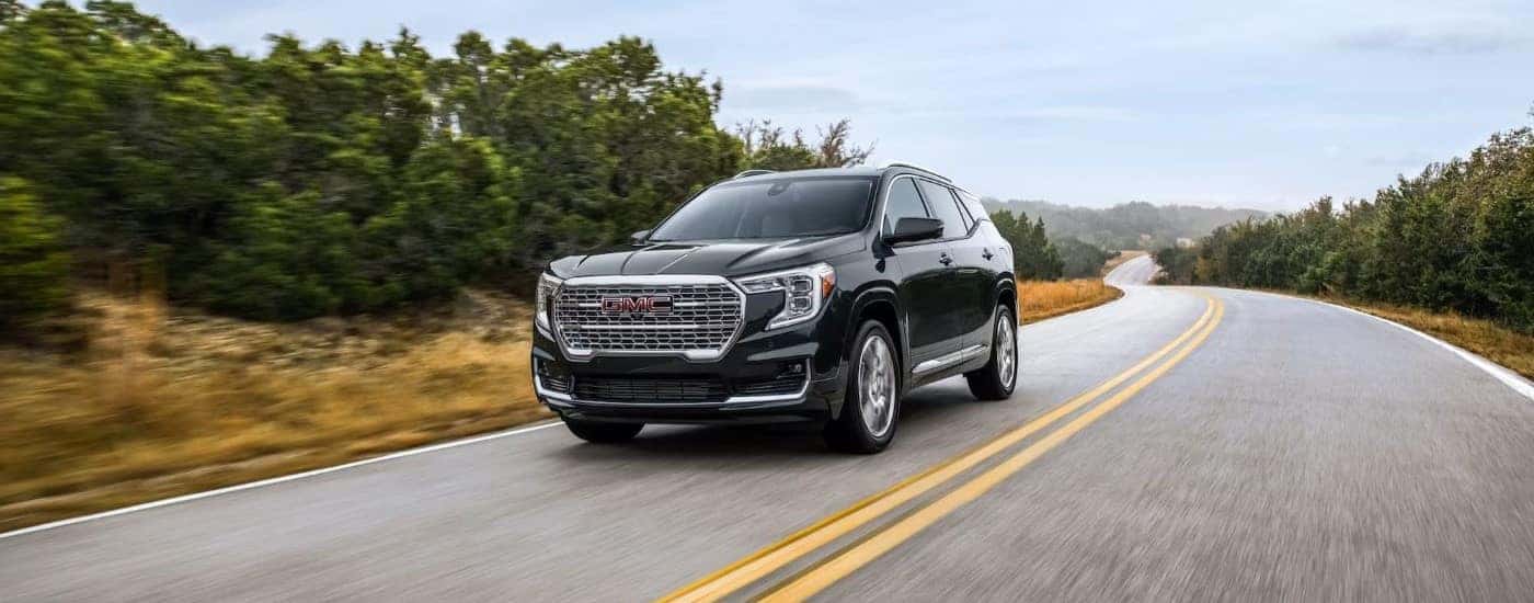 Black 2022 GMC Terrain Denali driving down an open road