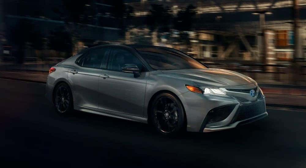 Silver 2024 Toyota Camry XSE Hybrid driving at night