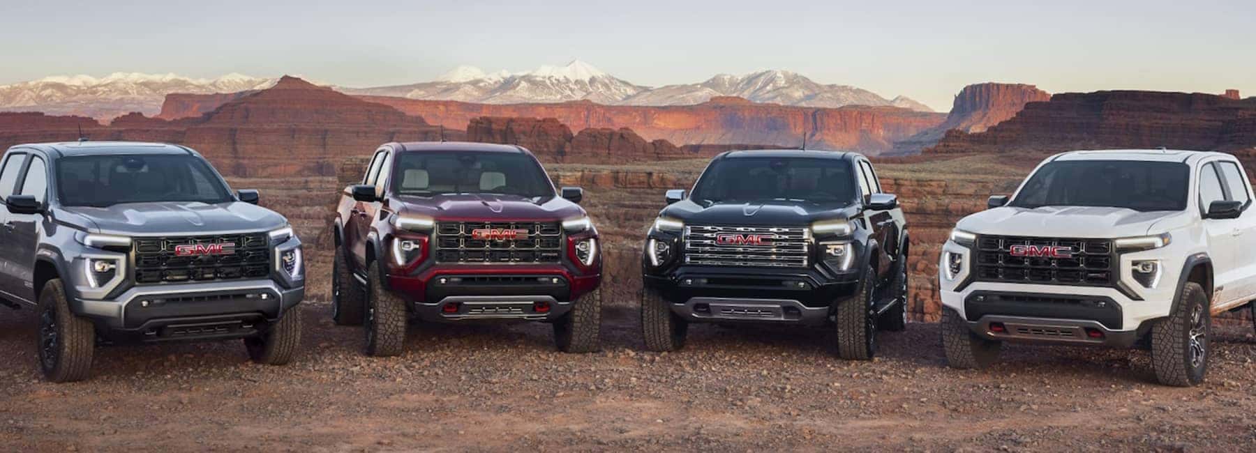 Group of 2023 GMC Canyon trucks parked off-road.
