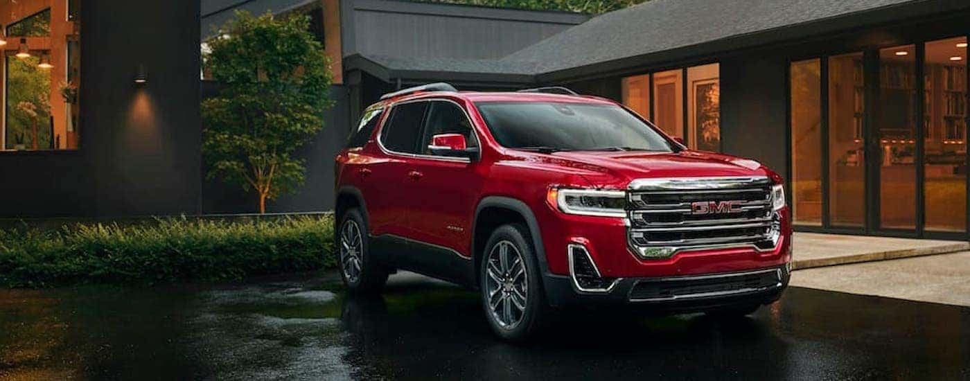 A red 2023 GMC Acadia is shown from the front at an angle after leaving a used GMC dealer.
