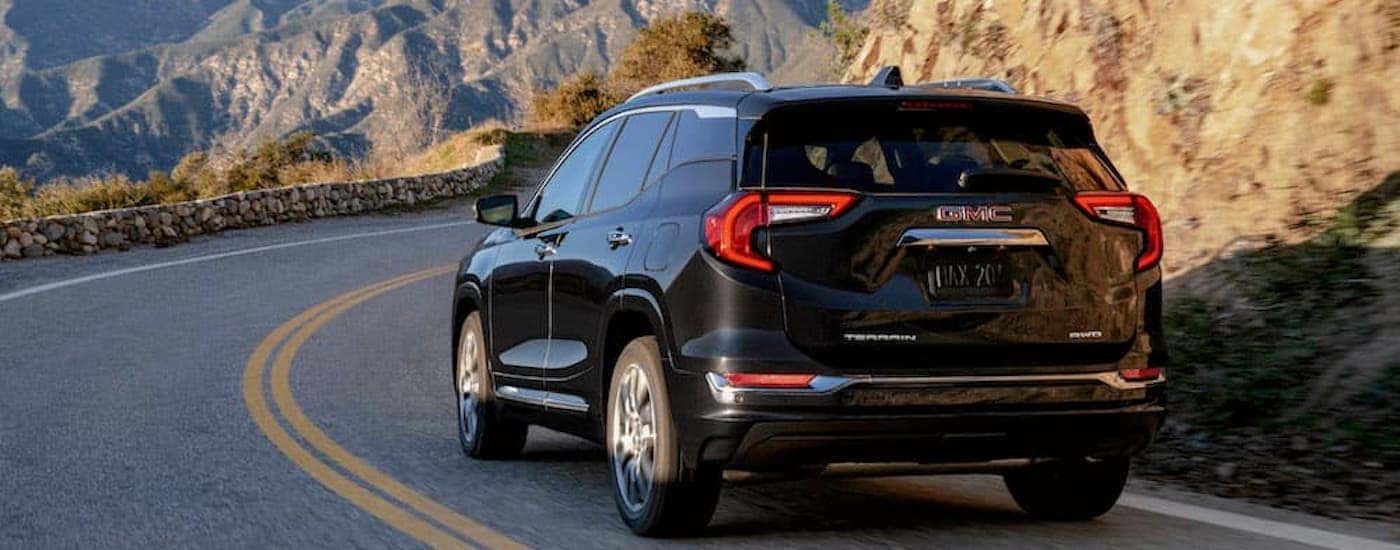 A black 2024 GMC Terrain Denali is shown from the rear at an angle.