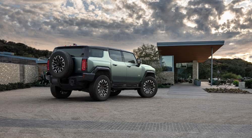 A green 2025 GMC Hummer EV is parked on a driveway.