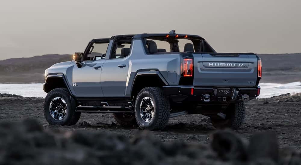 A white 2025 GMC Hummer EV is parked near a lake.