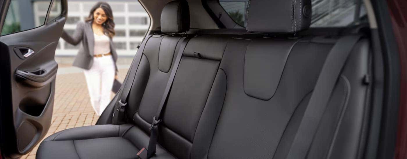 Woman opening the back door of a 2024 Buick Encore GX.