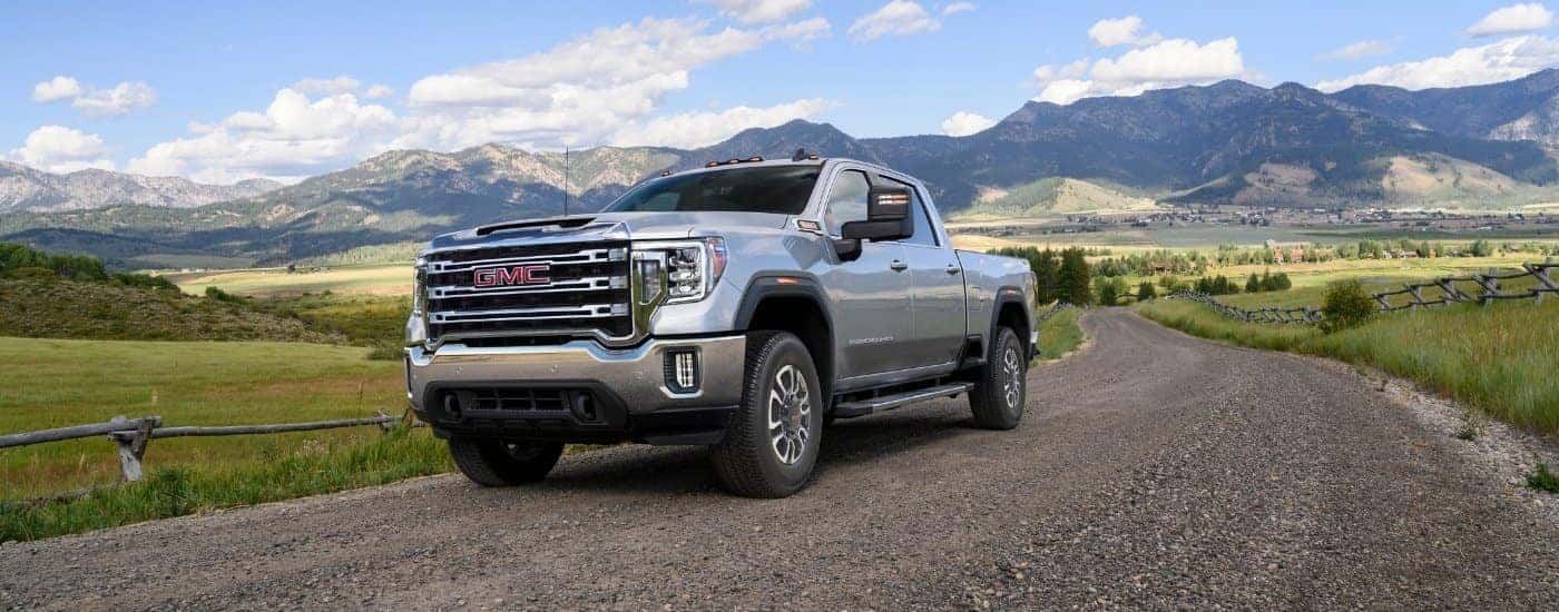 A silver 2023 GMC Sierra 2500 HD parked on a gravel trail.