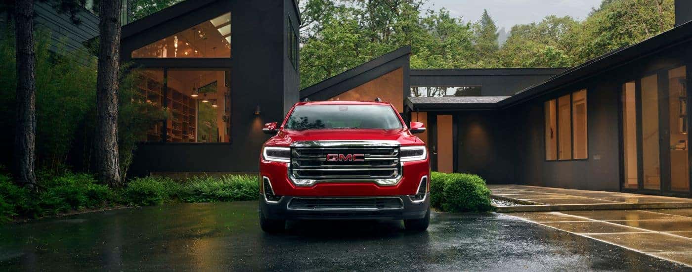 A red 2023 GMC Acadia is shown from the front after leaving a used GMC dealer in Greenville.