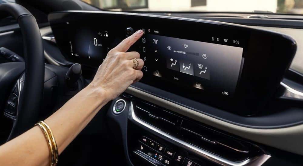 A woman using an infotainment display in a 2025 Buick Envista Avenir for sale