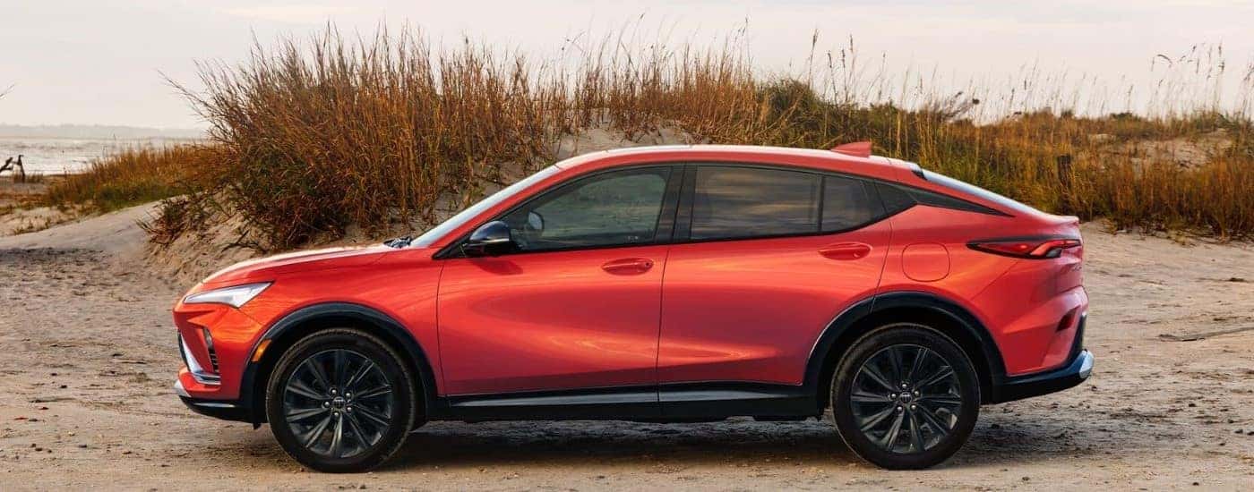 An orange 2024 Buick Envista parked off-road on sand