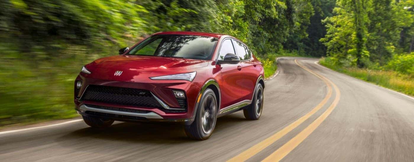 A red 2024 Buick Envista driving down a rural road