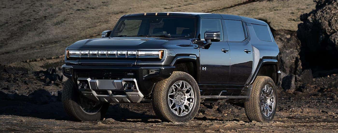 A black 2025 GMC Hummer EV parked off-road