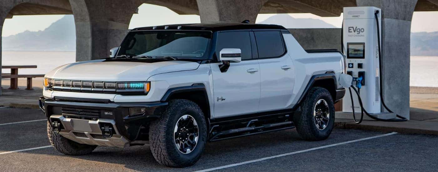 A white 2025 GMC Hummer EV charging at an EVgo station