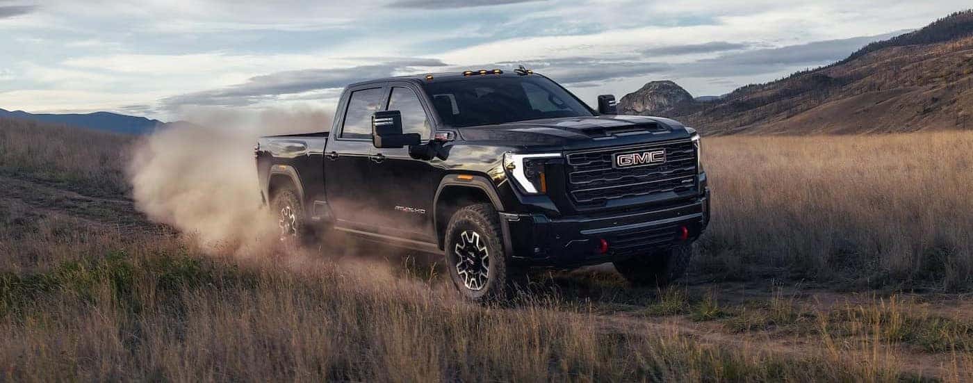 A black 2026 GMC Sierra 2500 driving off-road.