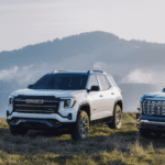 A black, a white and a blue 2026 GMC Terrain trio parked off road