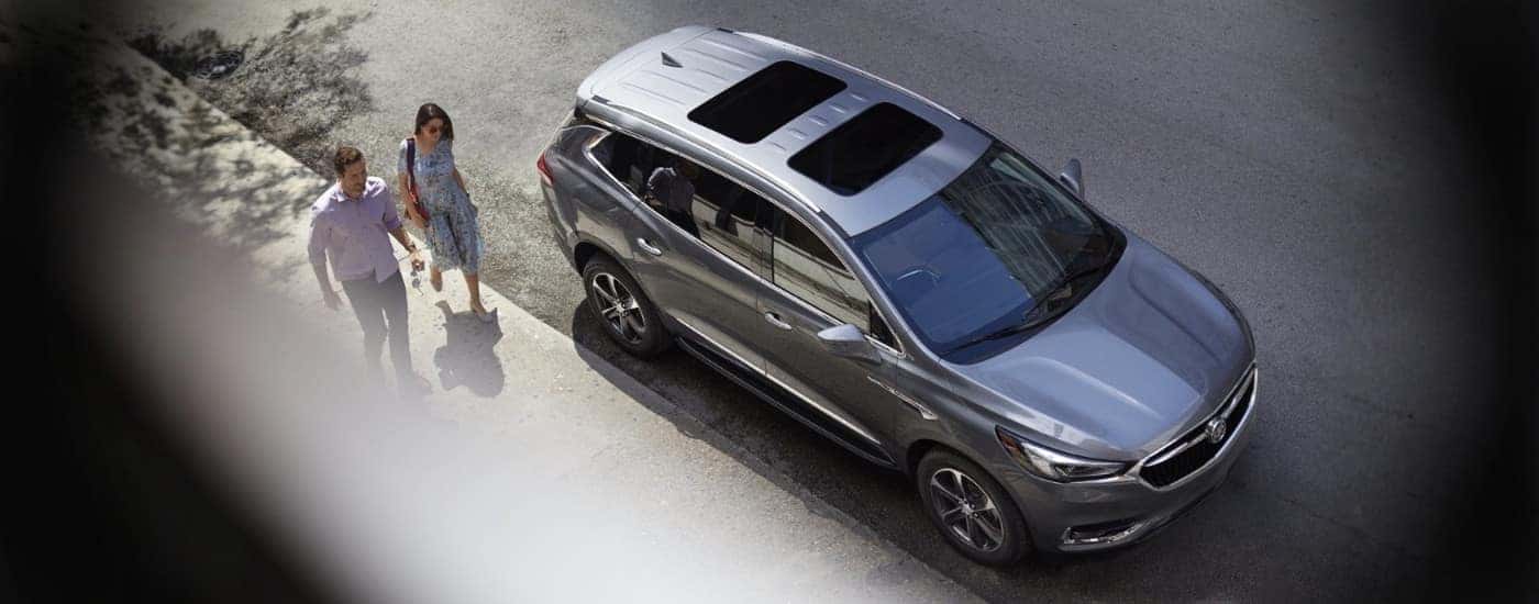 People approaching a grey 2019 Buick Enclave