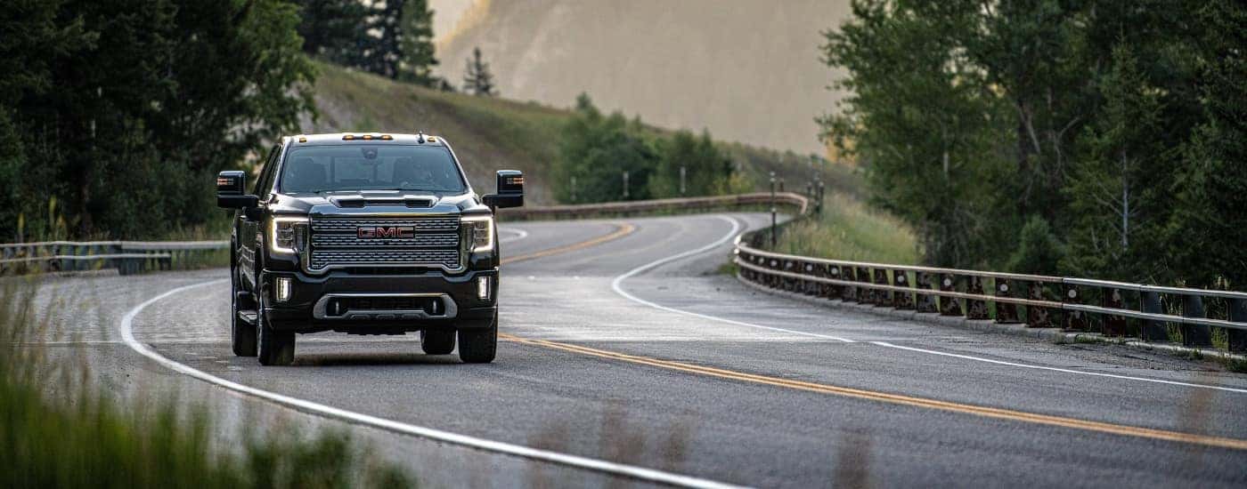 Black 2020 GMC Sierra 2500 HD Denali driving on a a winding road