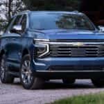 A blue 2025 Chevy Tahoe for sale near Houston parked near a forest.