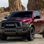 A marron 2023 Ram 1500 Classic is driving to look at used Trucks for sale in Tomball.