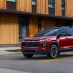A red 2025 Chevy Equinox RS parked at an intersection.