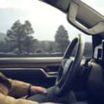 A person driving in a used 2024 Chevy Silverado for sale near Houston.
