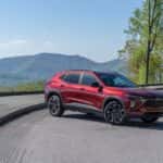 A red 2024 Chevy Trax RS is shown from the side after leaving a dealer that has a Chevy Trax for sale.