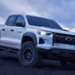 A white 2024 Chevy Colorado ZR2 Bison driving down a hill.