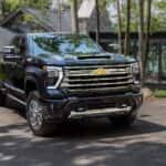 A black 2024 Chevy Silverado 2500 High Country parked outside a building and angled right.