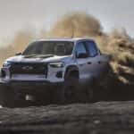 A silver 2024 Chevy Colorado ZR2 kicking up dust while off-roading.