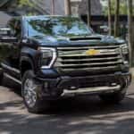 A black 2024 Chevy Silverado HD parked in front of a modern home.