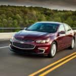 A red 2018 Chevy Malibu driving on an open highway.