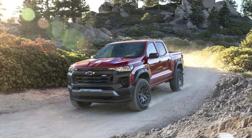 A red 2023 Chevy Colorado Trail Boss driving down a road.