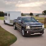 A black 2017 Chevy Silverado 1500 High Country towing a trailer.