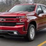 A red 2019 Chevy Silverado 1500 RST driving past a lake.