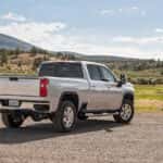 A silver 2022 Chevy Silverado 2500 HD is shown from the rear at an angle after leaving a truck dealer.