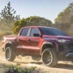 A red 2023 Chevy Colorado Trail Boss is shown from the front at an angle after leaving a truck dealer.