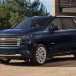A blue 2023 Chevy Tahoe High Country is shown parked near the Woodlands Chevy dealer.