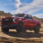 A red 2024 Chevy Silverado 2500 HD ZR2 Bison is shown from the front at an angle after leaving a Chevy Silverado dealer near Fulshear, TX.