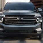 A black 2021 Chevy Tahoe is shown driving on a city road.