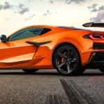 An orange 2021 Chevy Corvette Z06 is shown from the side parked on a street during the Chevy pre-order process.