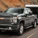 A green 2022 Chevy Silverado 2500 HD is shown from the front towing a closed trailer.