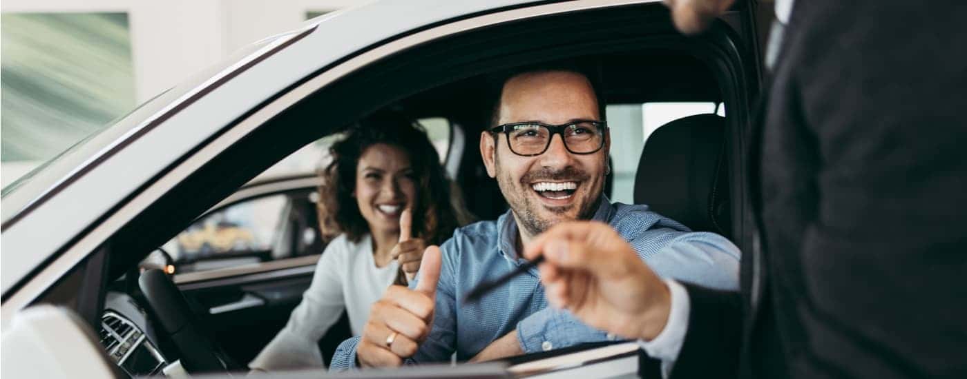 A couple is shown speaking to a Conroe Chevy dealer salesman