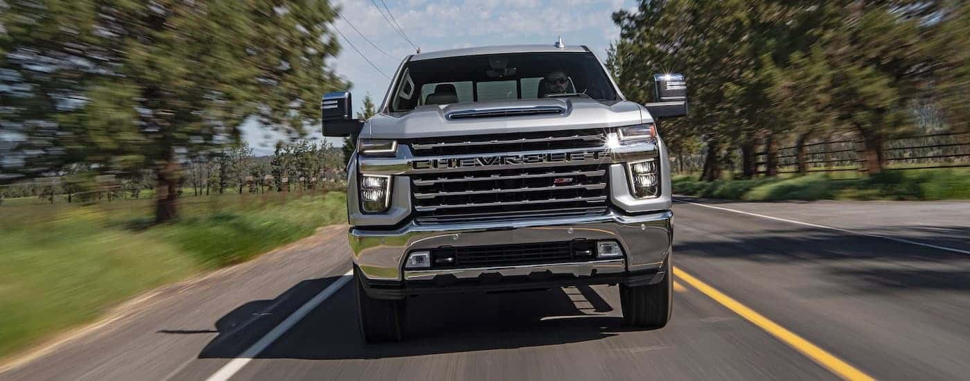 A silver 2020 Chevy Silverado 2500 HD Z71 is shown from the front driving on an open road
