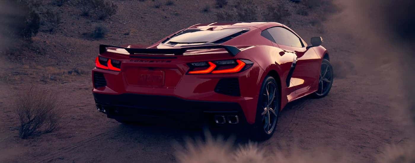 An orange 2021 Chevy Corvette is shown from the rear with the taillights illuminated