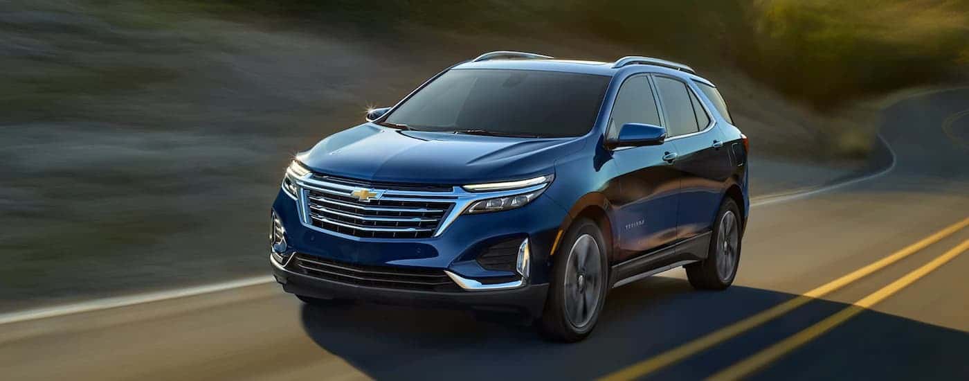A blue 2022 Chevy Equinox is shown on a highway after leaving The Woodlands Chevrolet dealership
