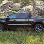 A black 2022 Chevy Silverado 1500 is shown from the side parked in a field after leaving a Tomball car dealership.