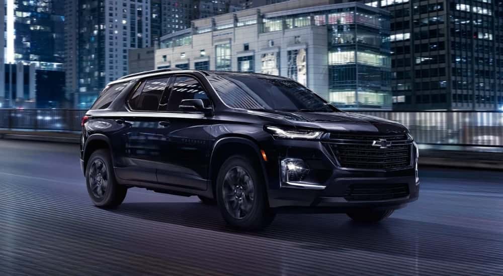 Black 2022 Chevy Traverse driving in a city
